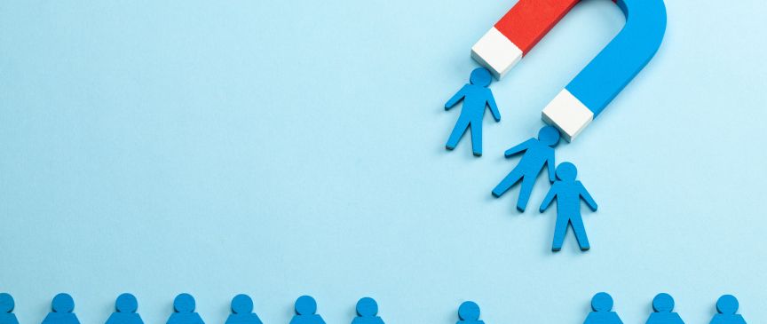 Viele blaue Männchen, von denen drei von einem großen Magneten angezogen werden.