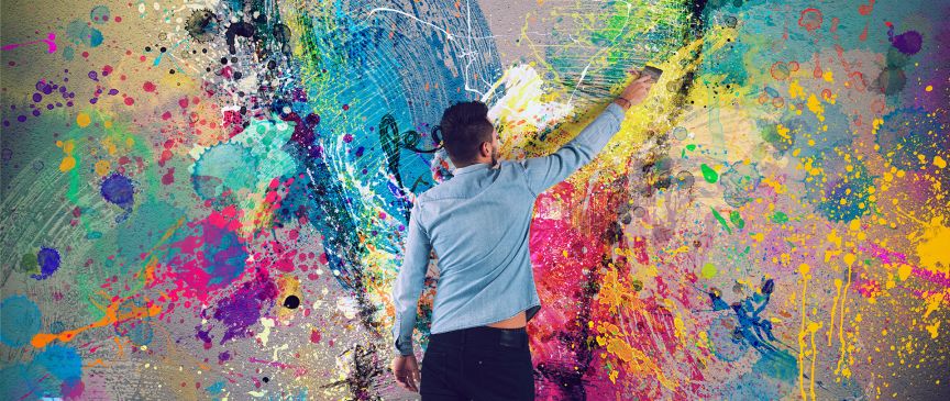 Mann vor einer Wand mit vielen Farben.