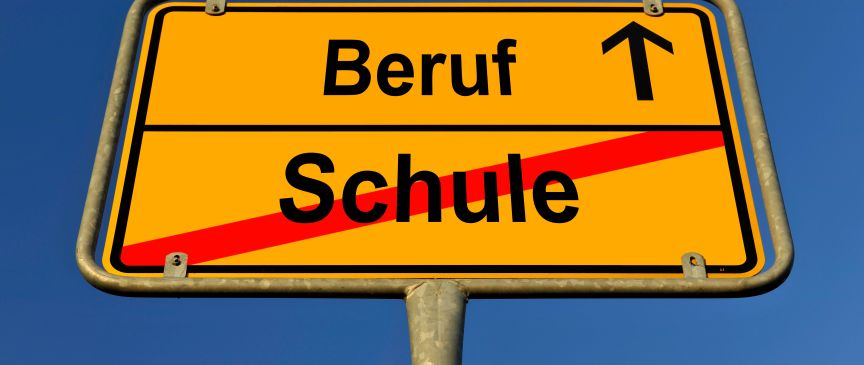 Gelbes Ortsschild mit Aufschrift „Beruf" (Pfeil hoch) und durchgestrichenem „Schule", blauer Himmel.