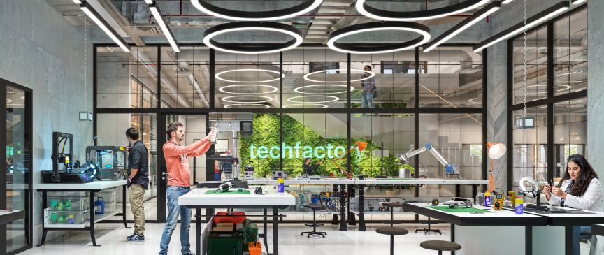 techfactory Labor, mehrere Studierende an der Arbeit und am Forschen, helles Licht, weiße Tische