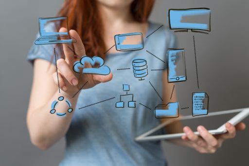 Frau berührt holografische Grafik mit Cloud, Geräten und Netzwerk-Icons, hält Tablet in der Hand.