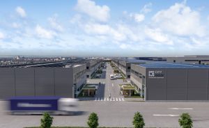 Luftperspektive eines modernen Industrieparks mit grauen Lagerhallen, Straße, LKW und Solaranlagen auf den Dächern.