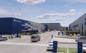 Panattoni-Logistikzentrum mit blauer Fassade, Parkplatz mit E-Ladesäulen, Lieferfahrzeuge und Fußgänger auf dem Gelände.