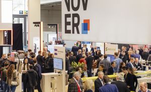 Messestand mit großem "Hannover"-Schriftzug, darunter viele Besucher in einer belebten Ausstellungshalle.