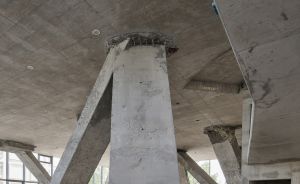 Betonpfeiler mit diagonalen Stützen tragen eine massive Betondecke in einem unfertigen Gebäude.