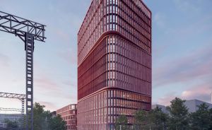 Modernes Hochhaus mit roter Fassade und horizontalen Lamellen neben Bahngleisen, Abenddämmerung, belebte Straße.