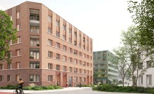 Rotes Backsteingebäude mit 5 Etagen, Balkonen, Radfahrer im Vordergrund, grüne Bäume, Pflasterweg, modernes Stadtquartier.