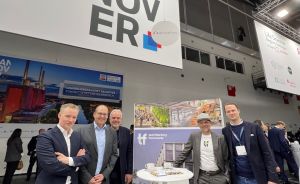 Fünf Männer stehen vor einem Messestand mit Hannover-Logo und einem Techfactory-Hannover-Aufsteller in einer Messehalle.