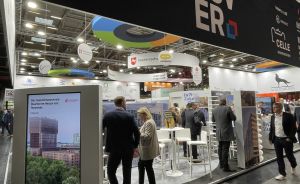 Messestand der Region Hannover mit Niedersachsen-Logo, weißen Stehtischen und mehreren Besuchern in einer Messehalle.