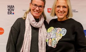Zwei Frauen mit Brille stehen lächelnd vor einem Banner des Niedersächsischen Unternehmerinnenkongresses in Hannover.