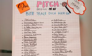 Flipchart mit handgeschriebenem Anmeldeformular „Dein Spontan-Pitch", 60 Sek., Beginn 11:15 Uhr, zwei Spalten mit Namen.
