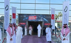 Eingang zur Messe „Industrial Transformation Saudi Arabia" mit rotem Teppich, Flaggen und mehreren Männern in weißen Thobes.