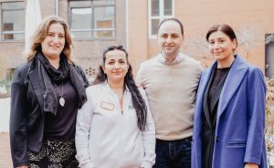 Drei Frauen und ein Mann stehen nebeneinander und schauen in die Kamera.