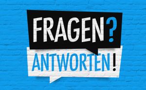 Blaue Ziegelwand mit zwei Sprechblasen: schwarze Blase "FRAGEN?" und weiße Blase "ANTWORTEN!" in blauer Schrift.