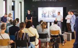 Präsentation beim #SmartStartAward von KPMG: Redner vor Publikum und Leinwand in einem modernen Veranstaltungsraum.