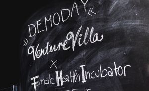 Kreidetafel mit der Aufschrift: „Demo Day – Venture Villa x Female Health Incubator" auf schwarzem Hintergrund.
