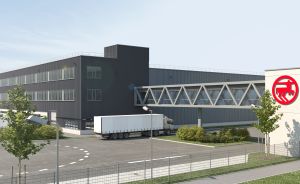 Modernes Industriegebäude mit LKW-Parkplatz, rotem Firmenlogo "MANN" auf weißem Turm, Außenanlage mit Bäumen.