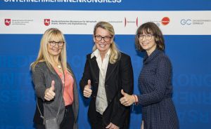 Drei Frauen mit Daumen hoch vor dem Banner des Niedersächsischen Unternehmerinnenkongresses in Hannover.