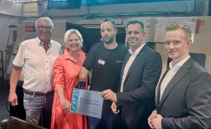 Fünf Personen stehen nebeneinander in einer Halle und halten gemeinsam ein Schild mit der Aufschrift „Digitaler Ort Niedersachsen".