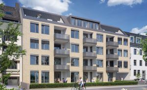 Modernes Mehrfamilienhaus mit heller Klinkerfassade, Balkonen und Dachterrasse, Fußgänger und Radfahrerin im Vordergrund.