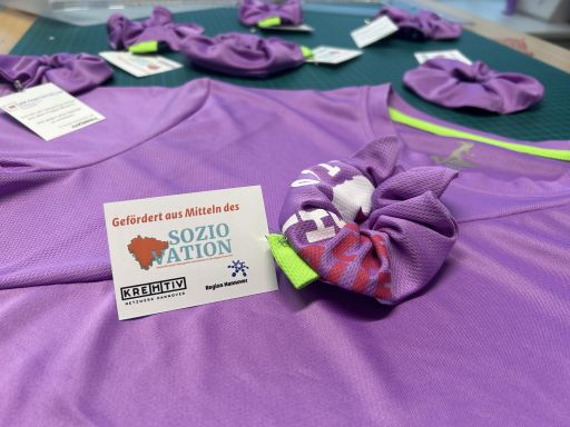 Haargummis, die im Projekt hergestellt wurde in Lila mit einem Schild dran.