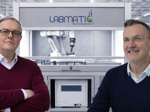 Zwei Männer vor einer Labmatic Automation-Maschine mit Roboterarm in einer Industriehalle.