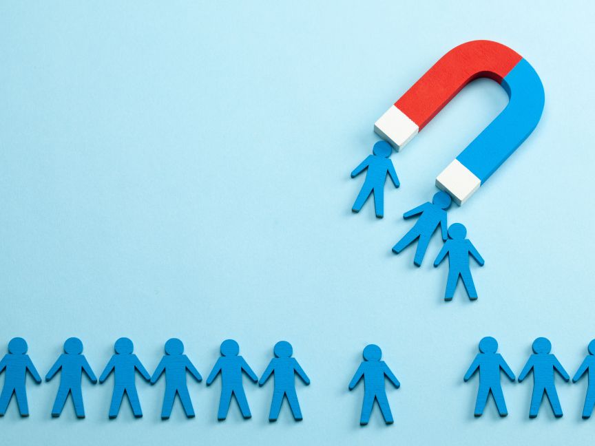 Viele blaue Männchen, von denen drei von einem großen Magneten angezogen werden.