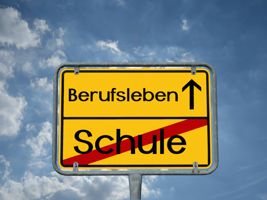 Gelbes deutsches Ortsschild mit „Berufsleben ↑" oben und durchgestrichenem „Schule" unten, vor blauem Himmel.