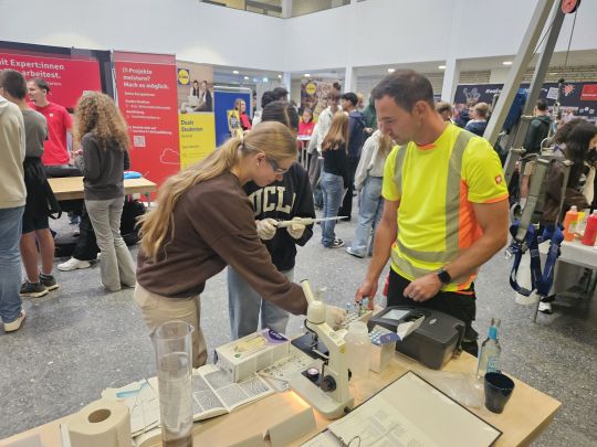 Mädchen am Messestand eines handwerklichen Berufs auf der Ausbildungmesse.