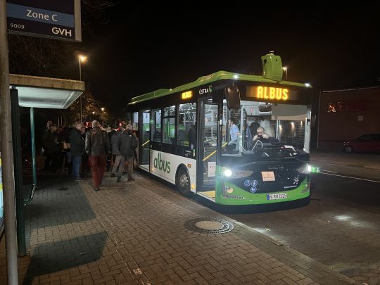 Der Albus-Bus steht an der Bushaltestelle, während Personen einsteigen.