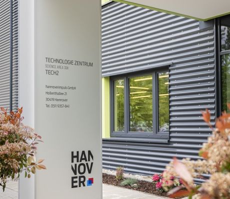 Schild des Technologie Zentrums Hannover (TECH2) mit Adresse Hollerithallee 21, 30419 Hannover, vor modernem Gebäude.