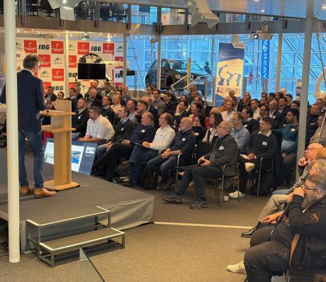 Das Publikum und ein Redner auf der Bühne.