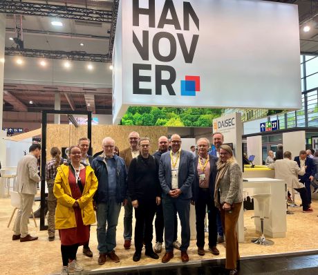 Gruppe an Menschen stehen auf dem HANNOVER-Stand auf der Messe.