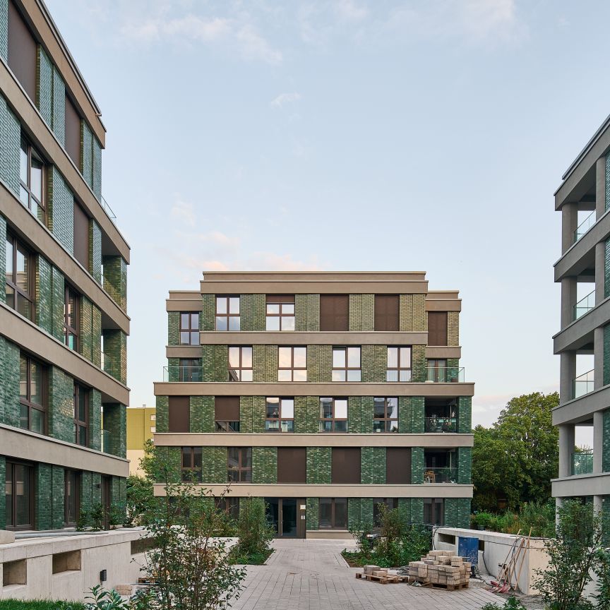 Ausseansicht von drei Wohnhäusern des Projektes Leineauen - zwei seitlich im Anschnitt und eines zentral in der Mitte