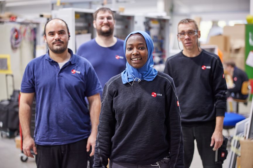 Drei Männer und eine Frau, Mitarbeitende der SKM Gesellschaft für Niederspannungs-Systemtechnik GmbH