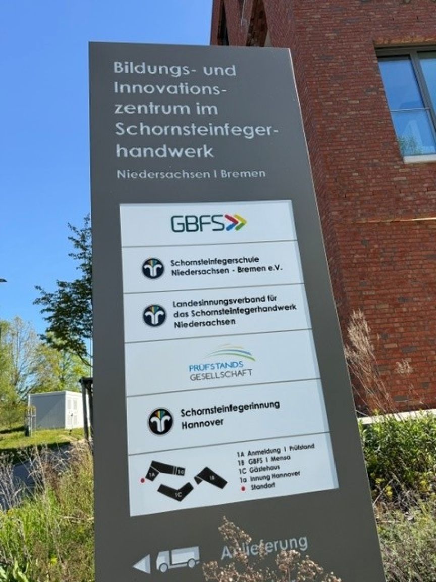 Wegweiserschild des Bildungs- und Innovationszentrums im Schornsteinfegerhandwerk Niedersachsen/Bremen mit GBFS-Logo.