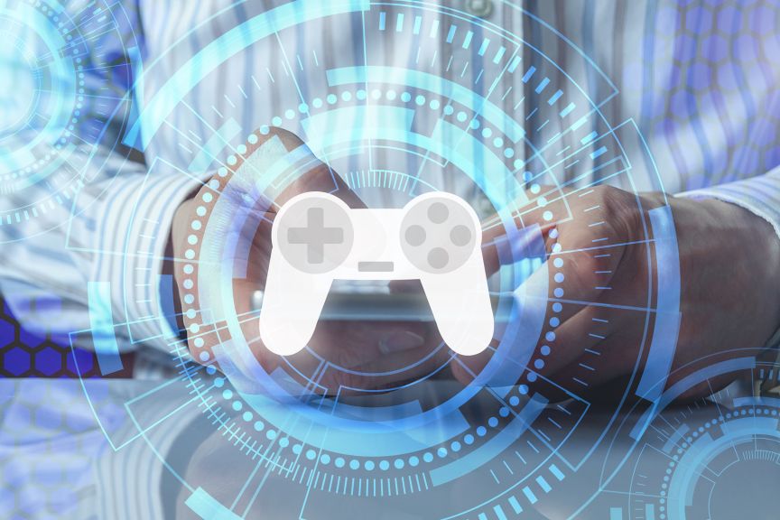 Person in gestreiftem Hemd hält Tablet; darüber blaues digitales HUD mit weißem Gamecontroller-Symbol.