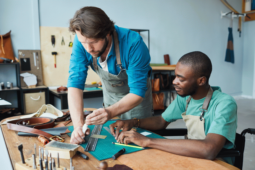 Zwei Personen sitzen vor einer Werkbank