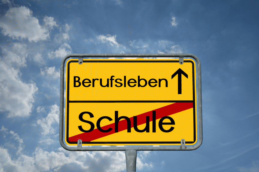 Gelbes deutsches Ortsschild mit „Berufsleben ↑" oben und durchgestrichenem „Schule" unten, vor blauem Himmel.