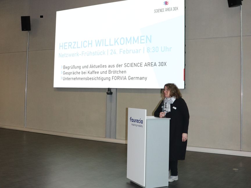 Frau am Faurecia-Podium präsentiert beim Netzwerk-Frühstück der Science Area 30X am 24. Februar, 8:30 Uhr.