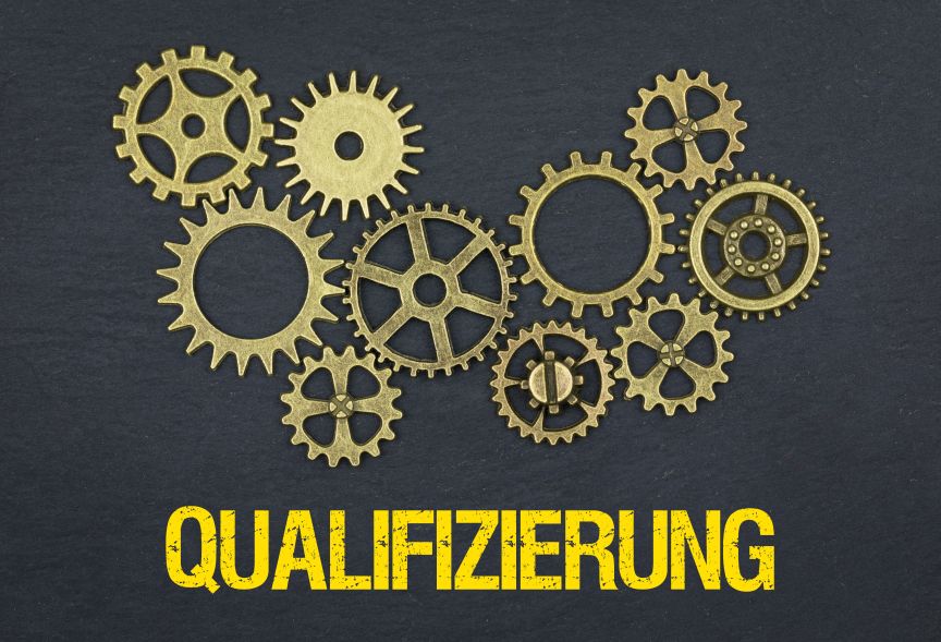 Mehrere goldene Zahnräder verschiedener Größen auf dunklem Hintergrund, darunter der Text „QUALIFIZIERUNG" in Gelb.